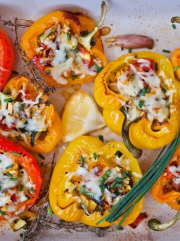 red and yellow bell peppers stuffed with chicken and onions on white counter