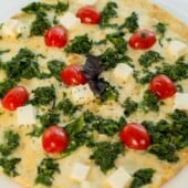 Pizza with spinach and cherry tomatoes.