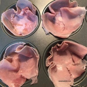 muffin tin lined with sliced ham
