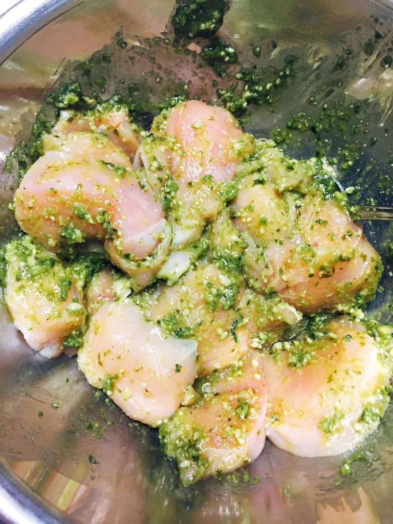 raw chicken mixed with pesto