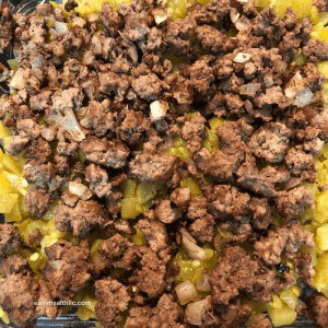 cooked ground beef over layer of green chilis