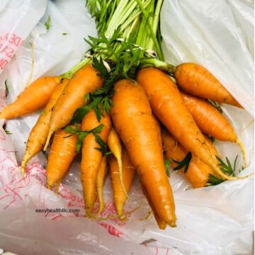 bunch of baby carrots with green tops