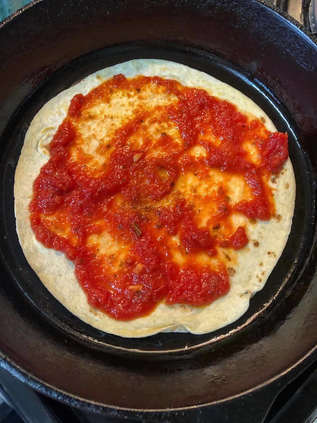 marinara on tortilla in skillet