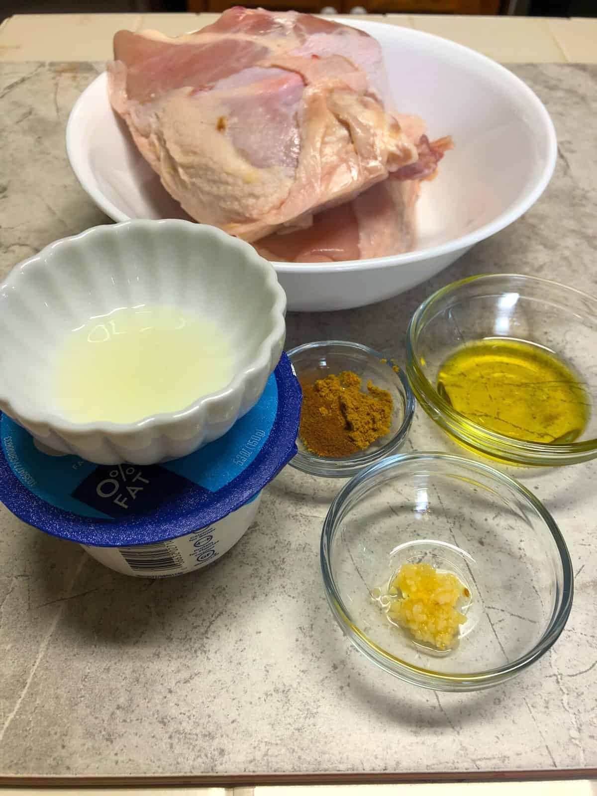 raw chicken, spices, oil, yogurt in small bowls