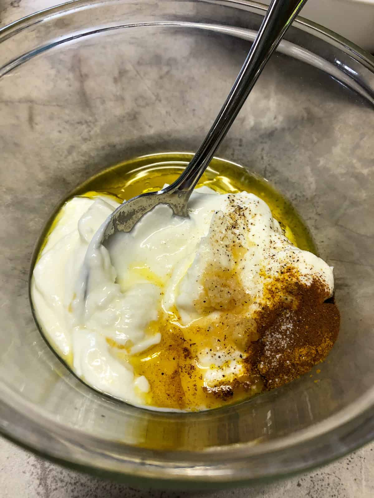 greek yogurt and spices in a clear bowl