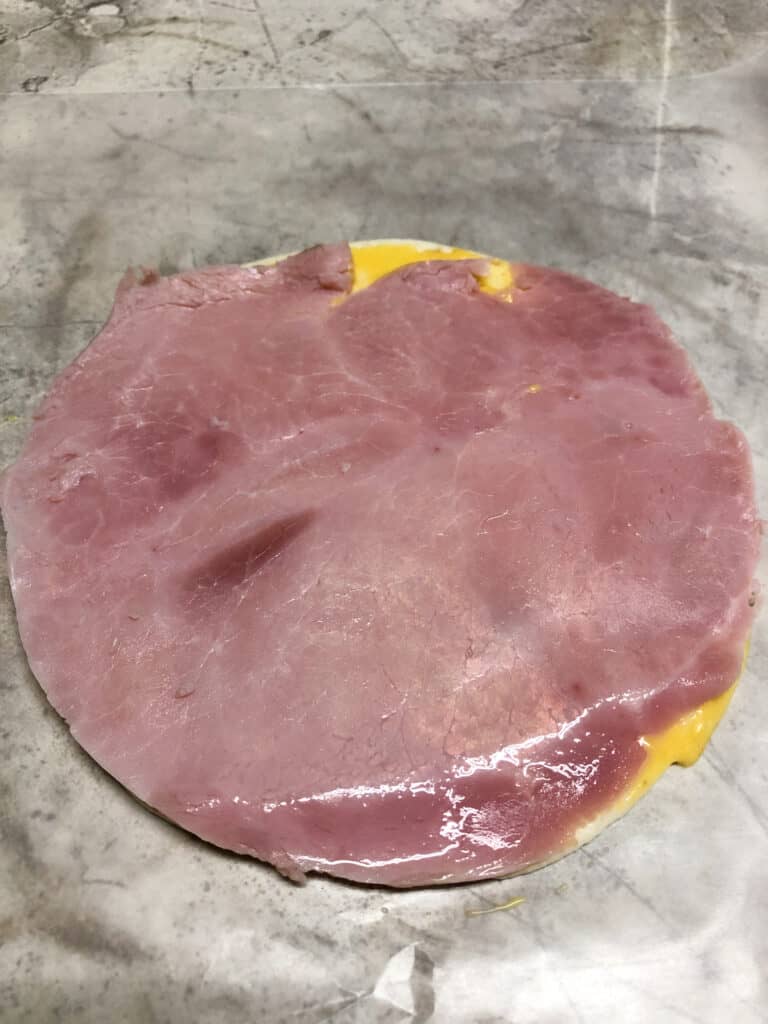 tortilla with ham on cutting board