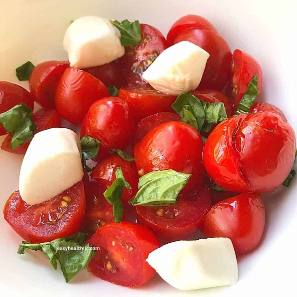 tomatoes, mozzarella salad in white bowl