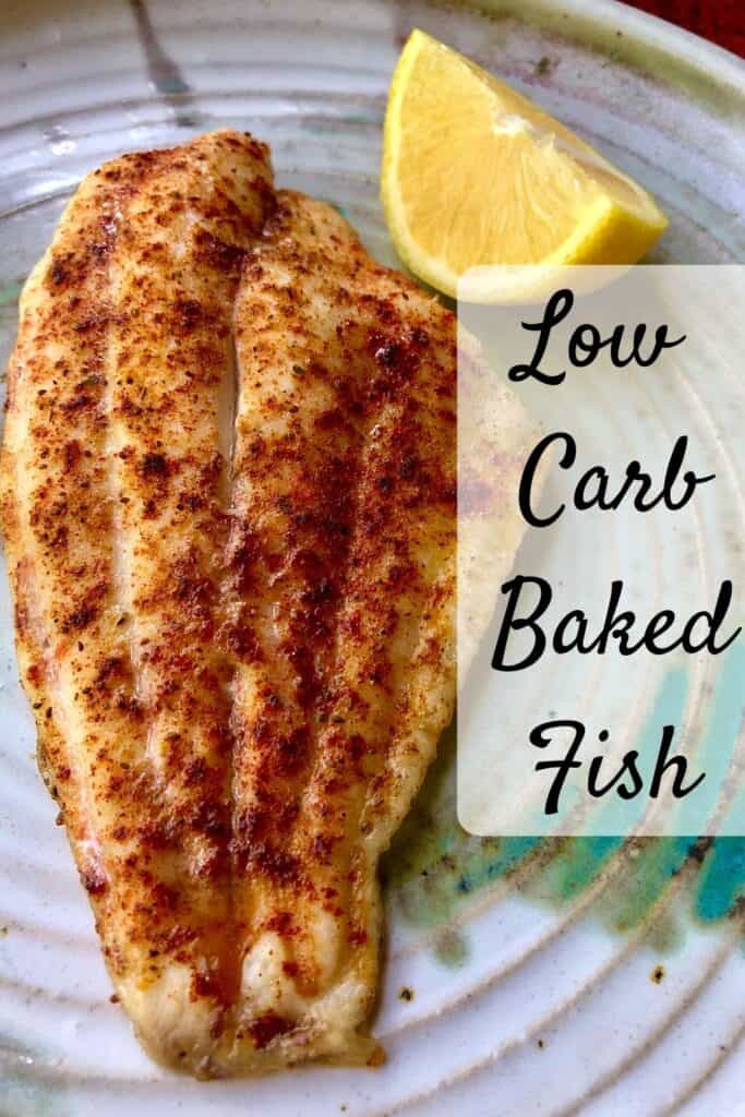 baked fish on plate with lemon wedge