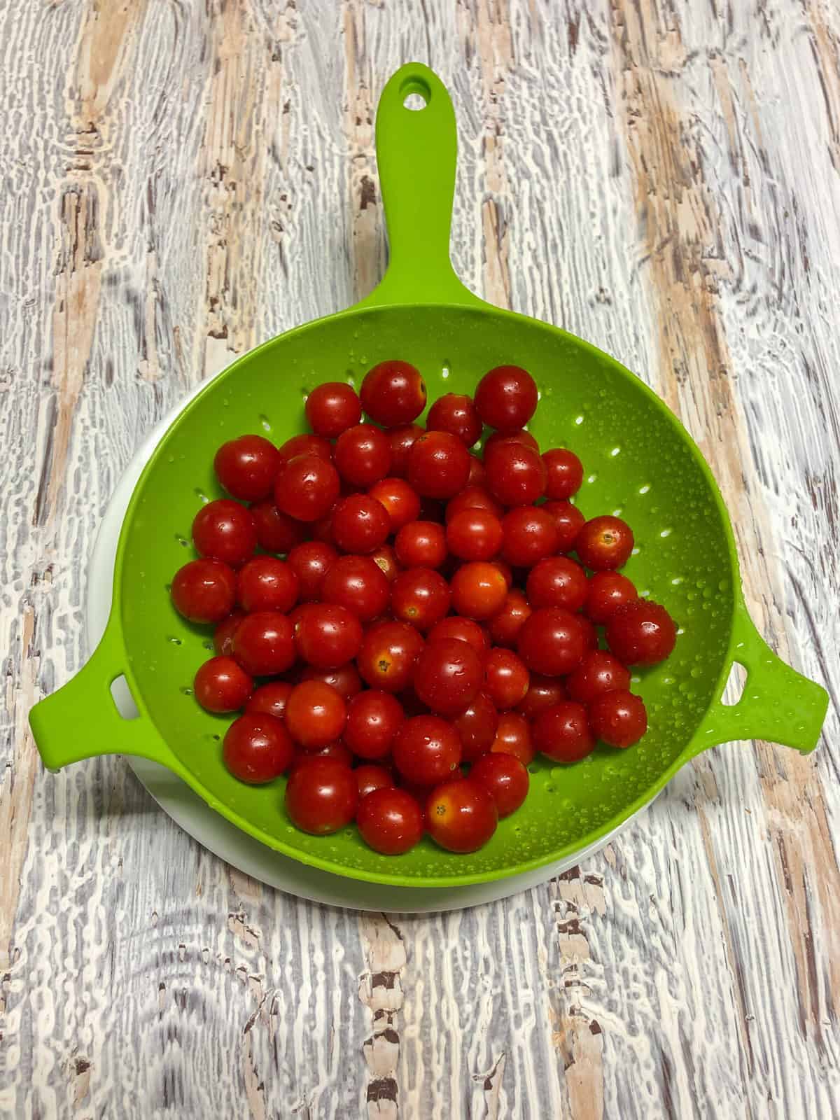 cherry tomatoes in green colander