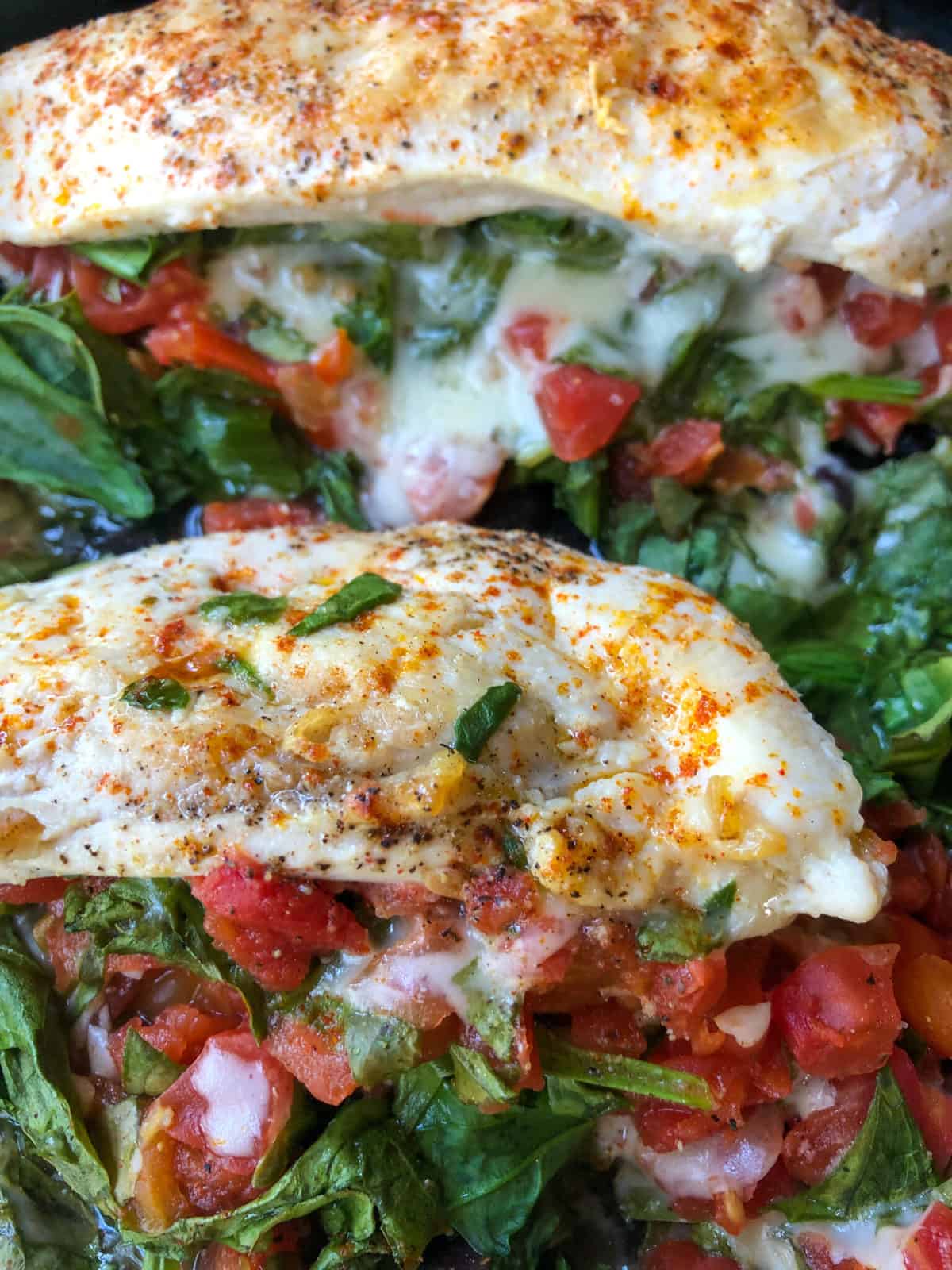 chicken breasts in skillet with spinach and rotel