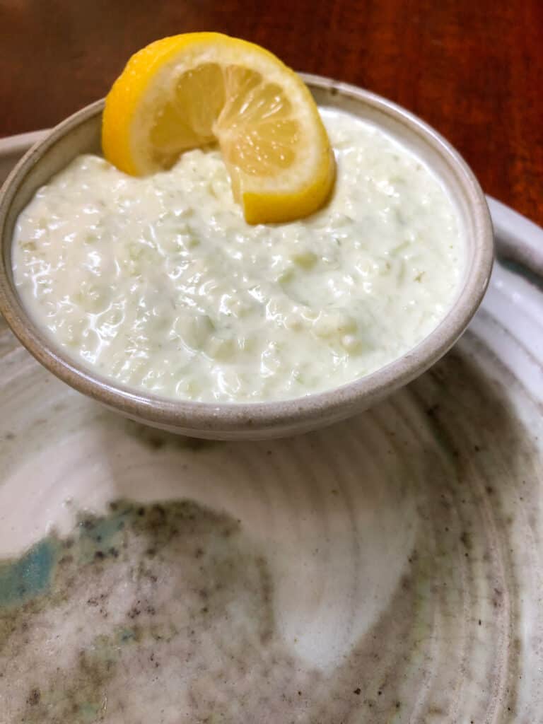 greek yogurt sauce in bowl with lemon slice