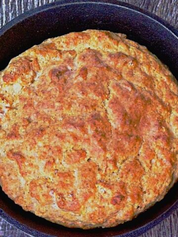 cooked cornbread in black skillet on wooden table