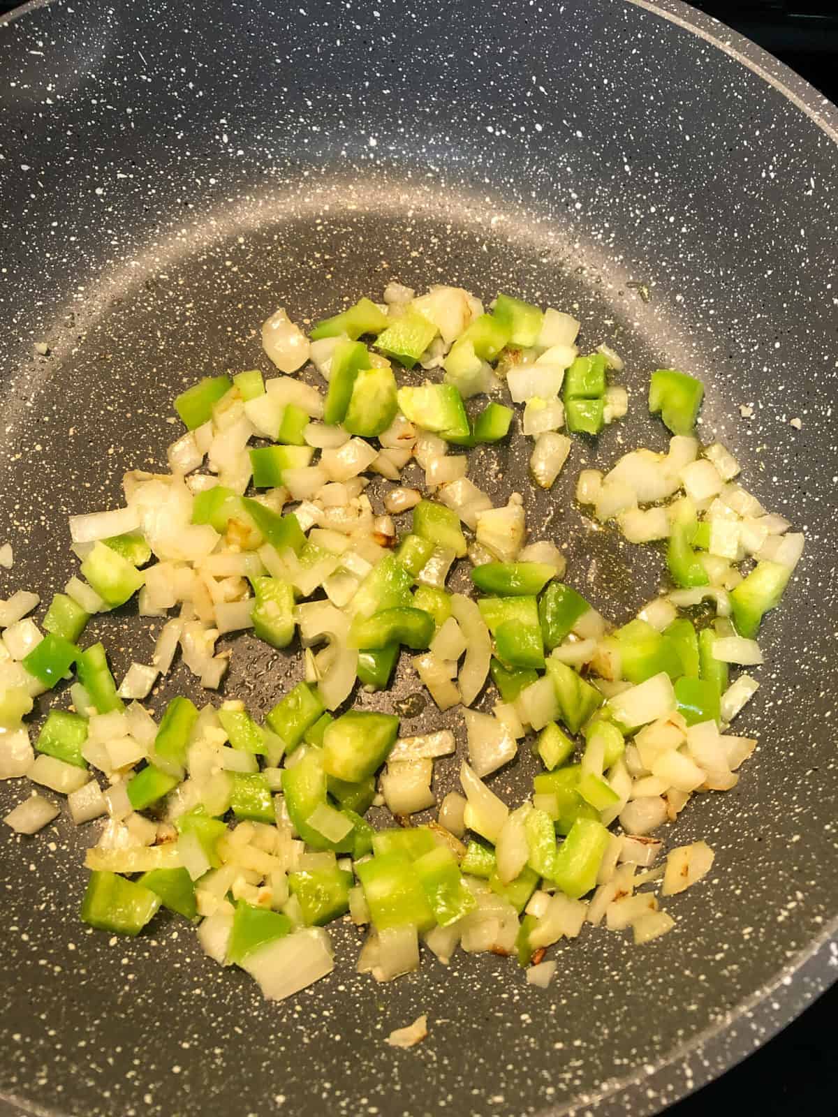 diced green bell peppers and onions in skillet