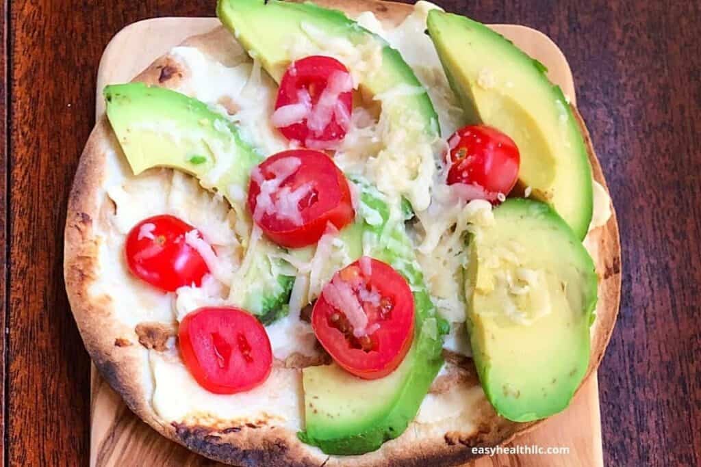 avocado pizza on wooden board