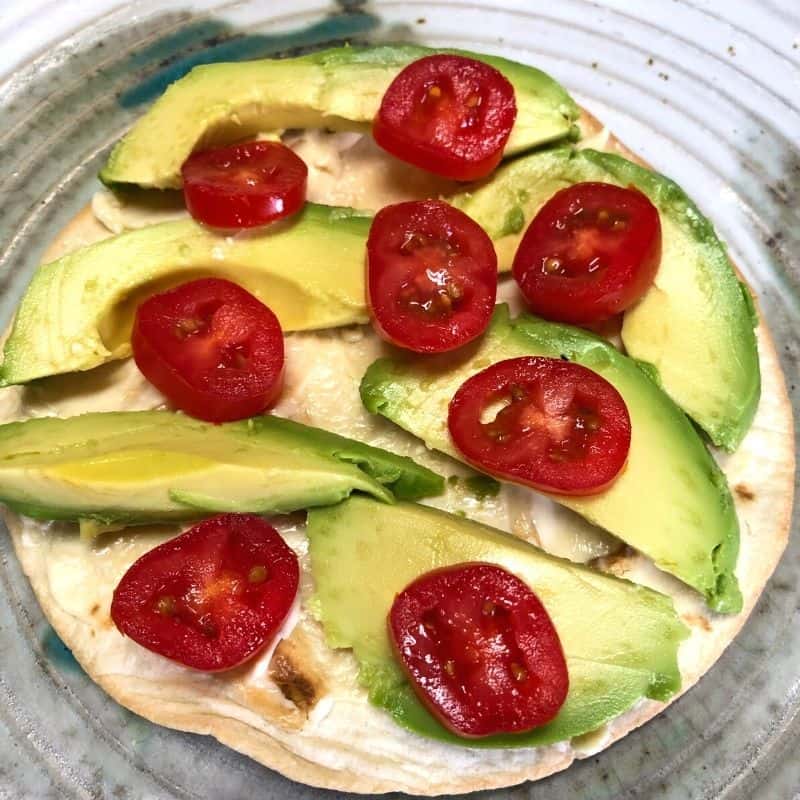 tortilla with tomatoes and sliced avocado