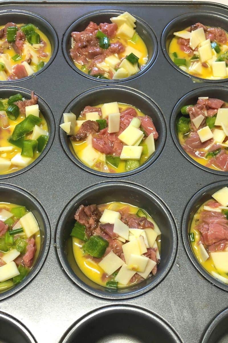 muffin tin filled with philly cheesesteak mixture