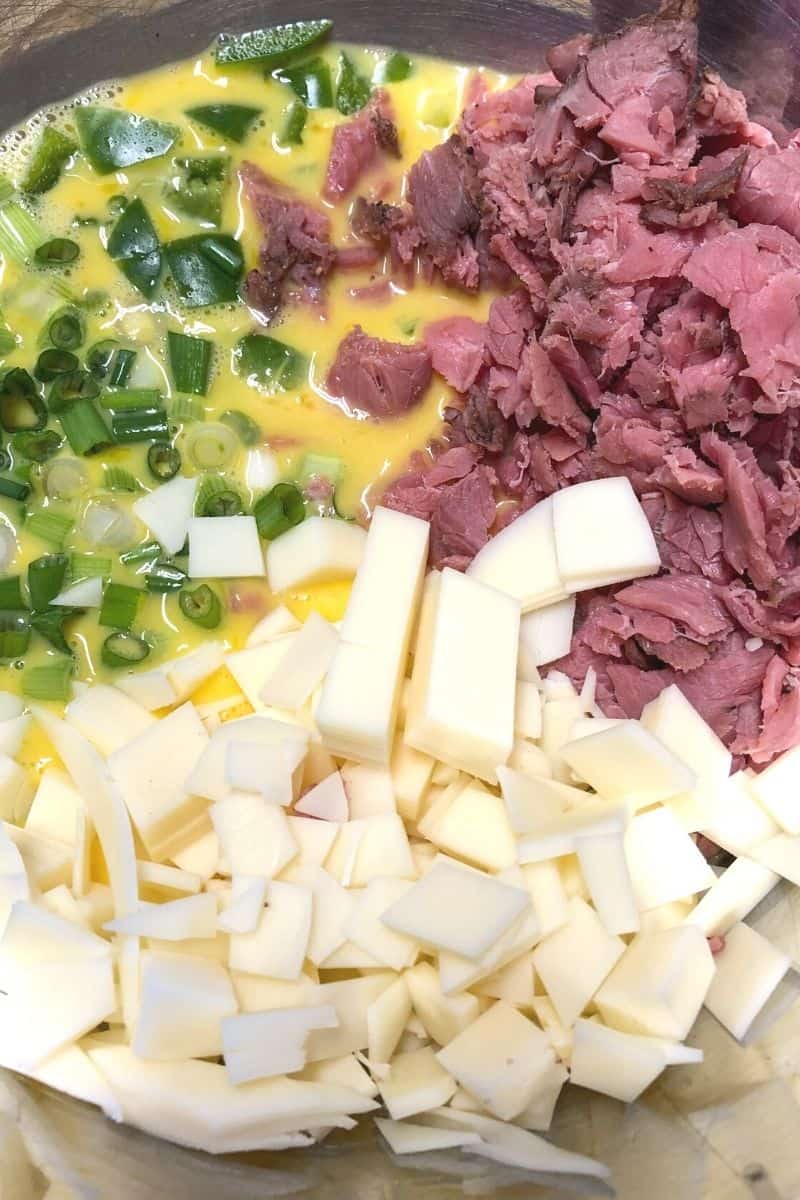 green peppers chopped, chopped cheese, eggs and beef in bowl