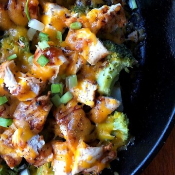 chopped potato with broccoli, chicken, bbq sauce and cheese in black skillet