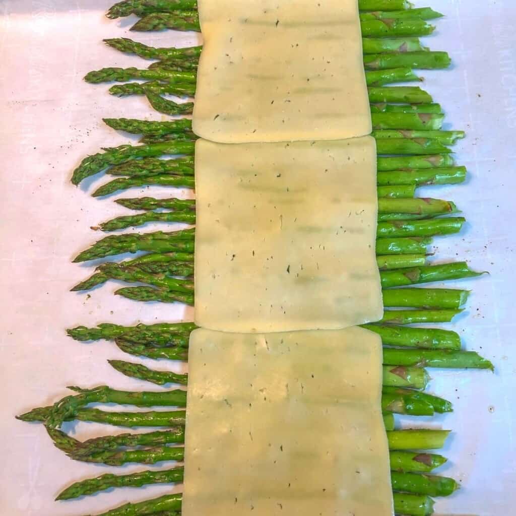 roasted asparagus spears with cheese slices on top