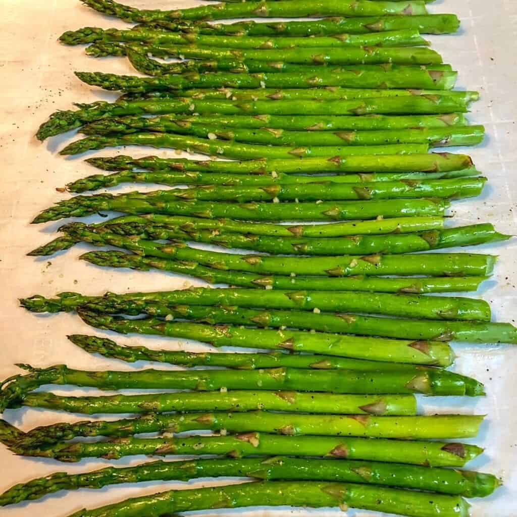 roasted asparagus spears on parchment paper