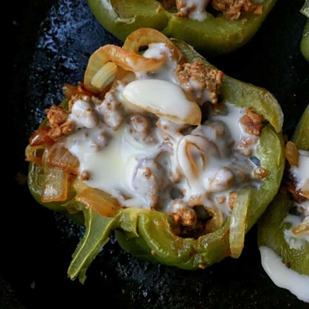 bell pepper half stuffed with philly cheesesteak and melted white cheese