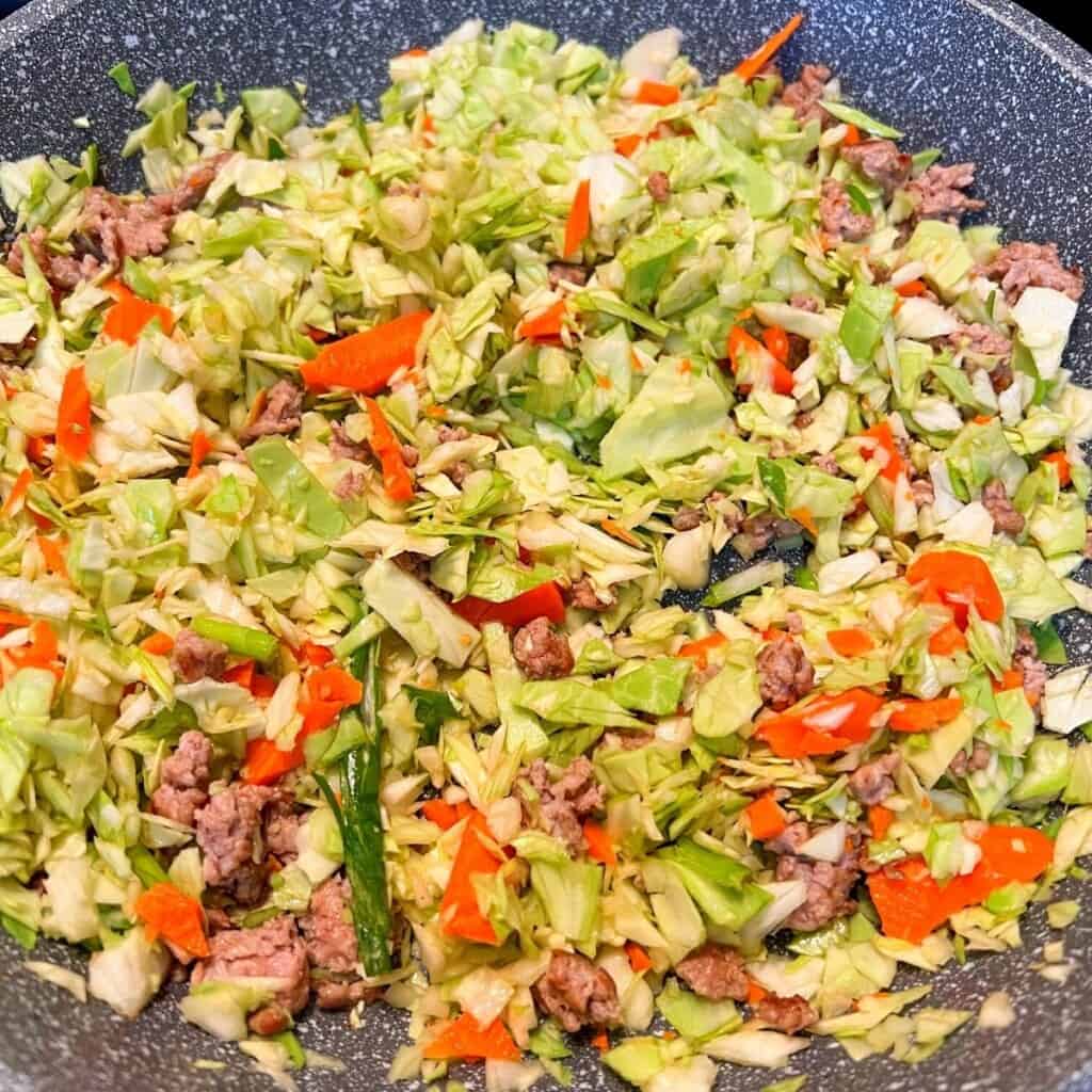 chopped cabbage and pork in skillet