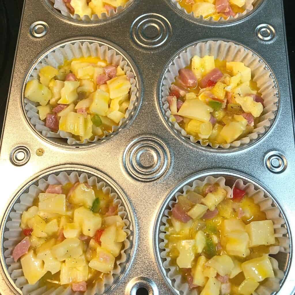 muffin tin filled with ingredients for grab and go hash brown muffins and ready for oven