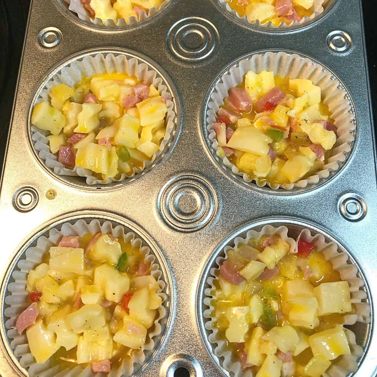 muffin tin filled with ingredients for grab and go hash brown muffins and ready for oven