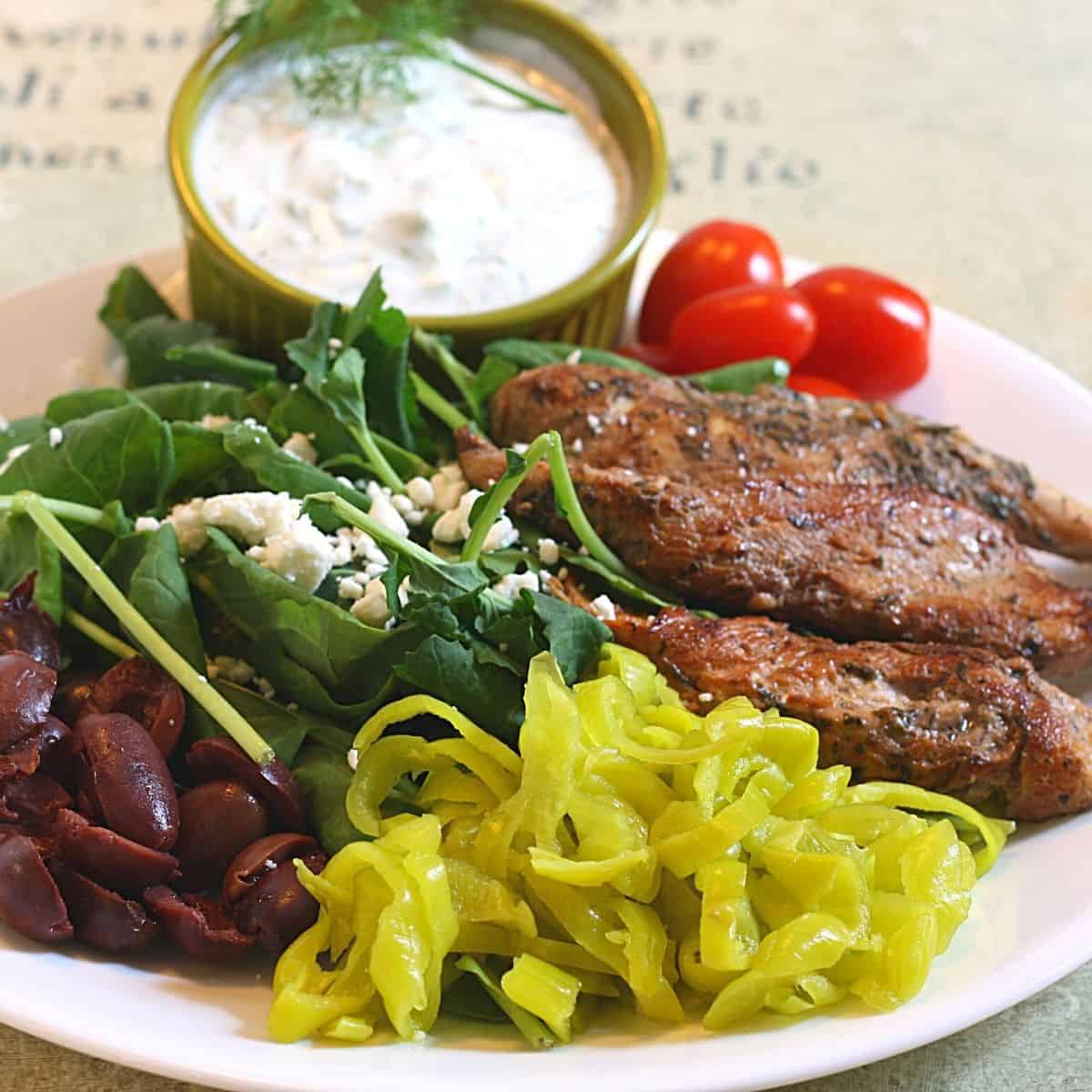 plate with greek chicken, tzatziki sauce, pepperoncini