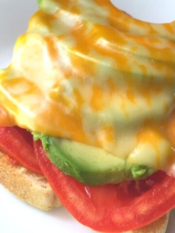 sliced tomatoes, avocado and melted cheese on toast