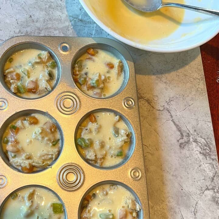 muffin tin filled with chicken muffin mixture and baking mix