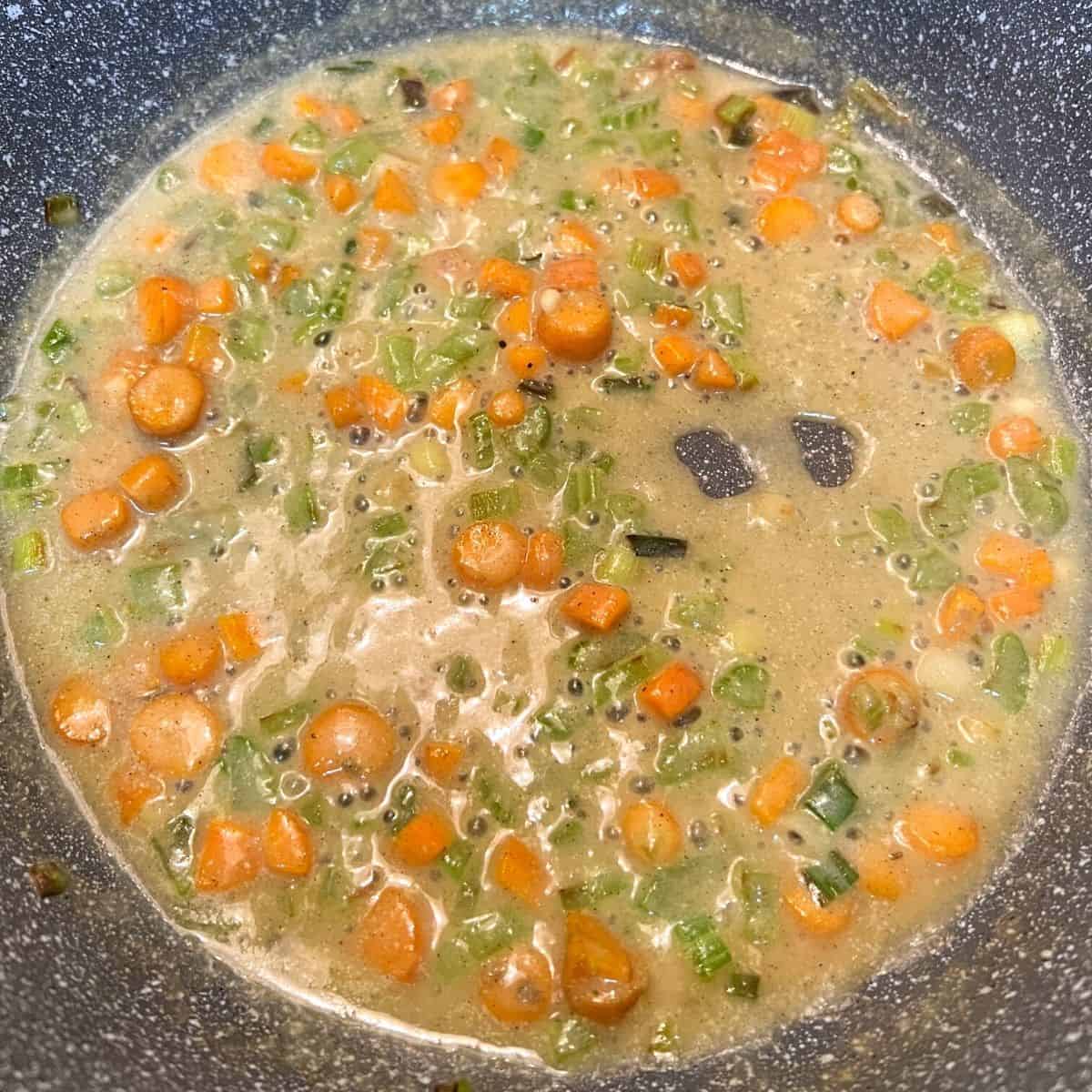 diced veggies in pan with broth