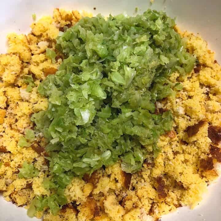 bowl of crumbled cornbread with mound of diced celery and onions