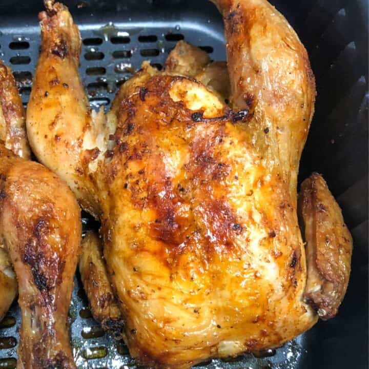 golden brown cornish hen in air fryer basket