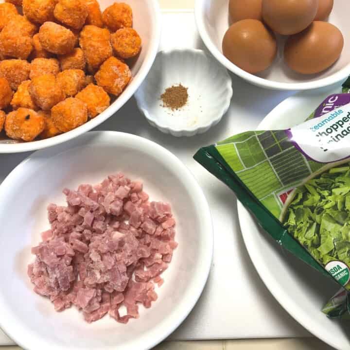 bowls of ingredients for egg spinach muffins- tots, ham chunks, eggs, spinach
