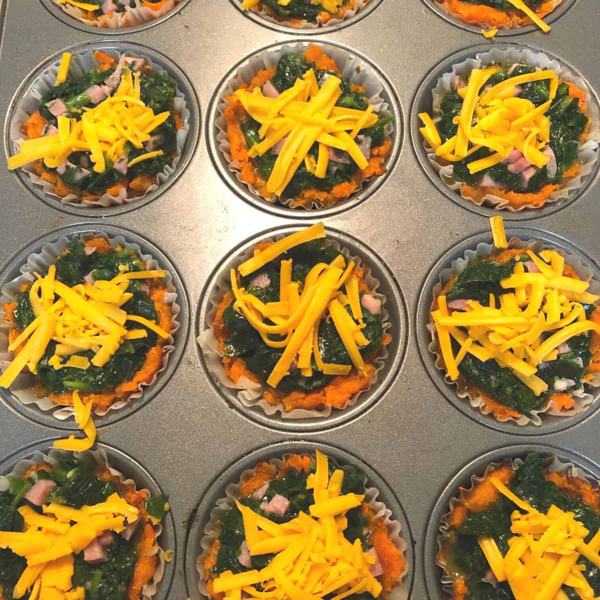 egg spinach muffin ingredients in muffin tin ready for oven