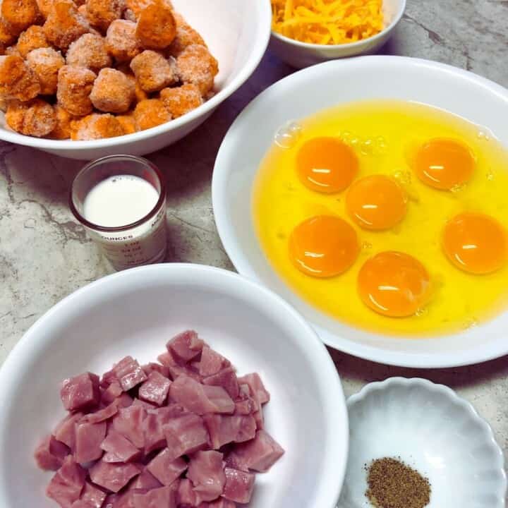 ingredients for sweet potato tot breakfast casserole, bowls of eggs, tots,ham,cheese