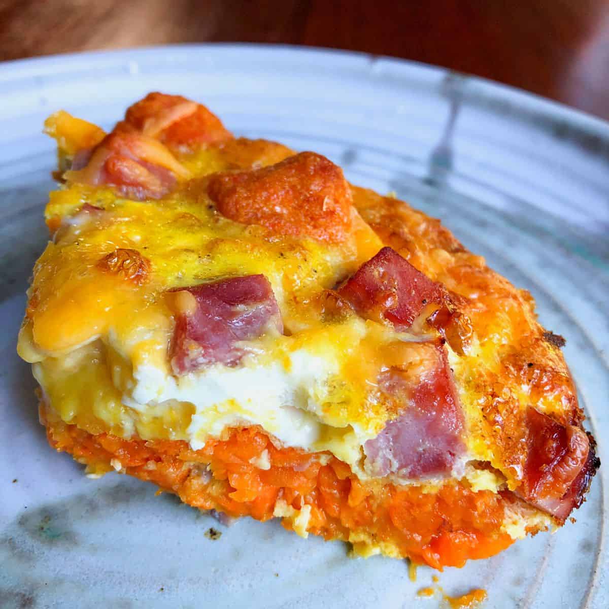 slice of sweet potato tot breakfast casserole on pottery plate