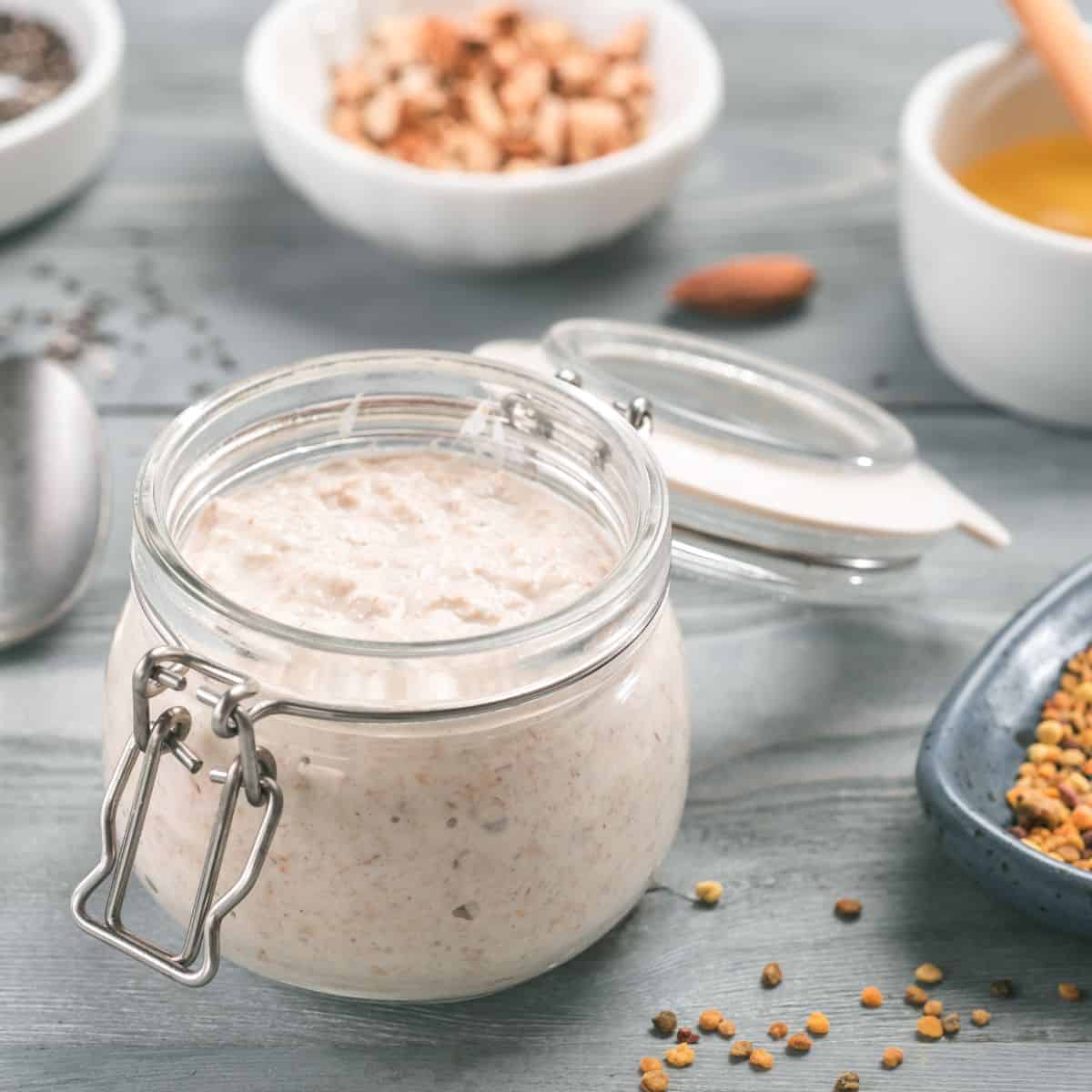 Overnight oats in glass jar with bowls of toppings