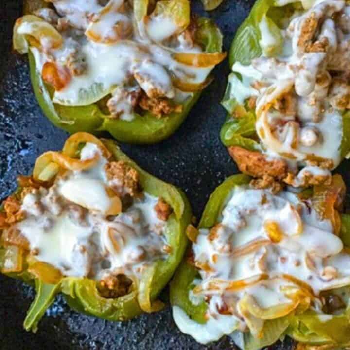 green bell peppers stuffed with cheesesteak in black skillet