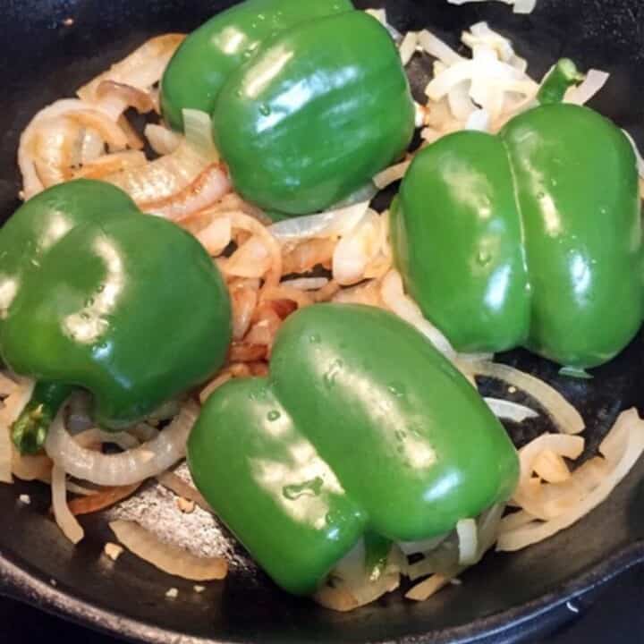 green bell peppers on chopped onions in skillet