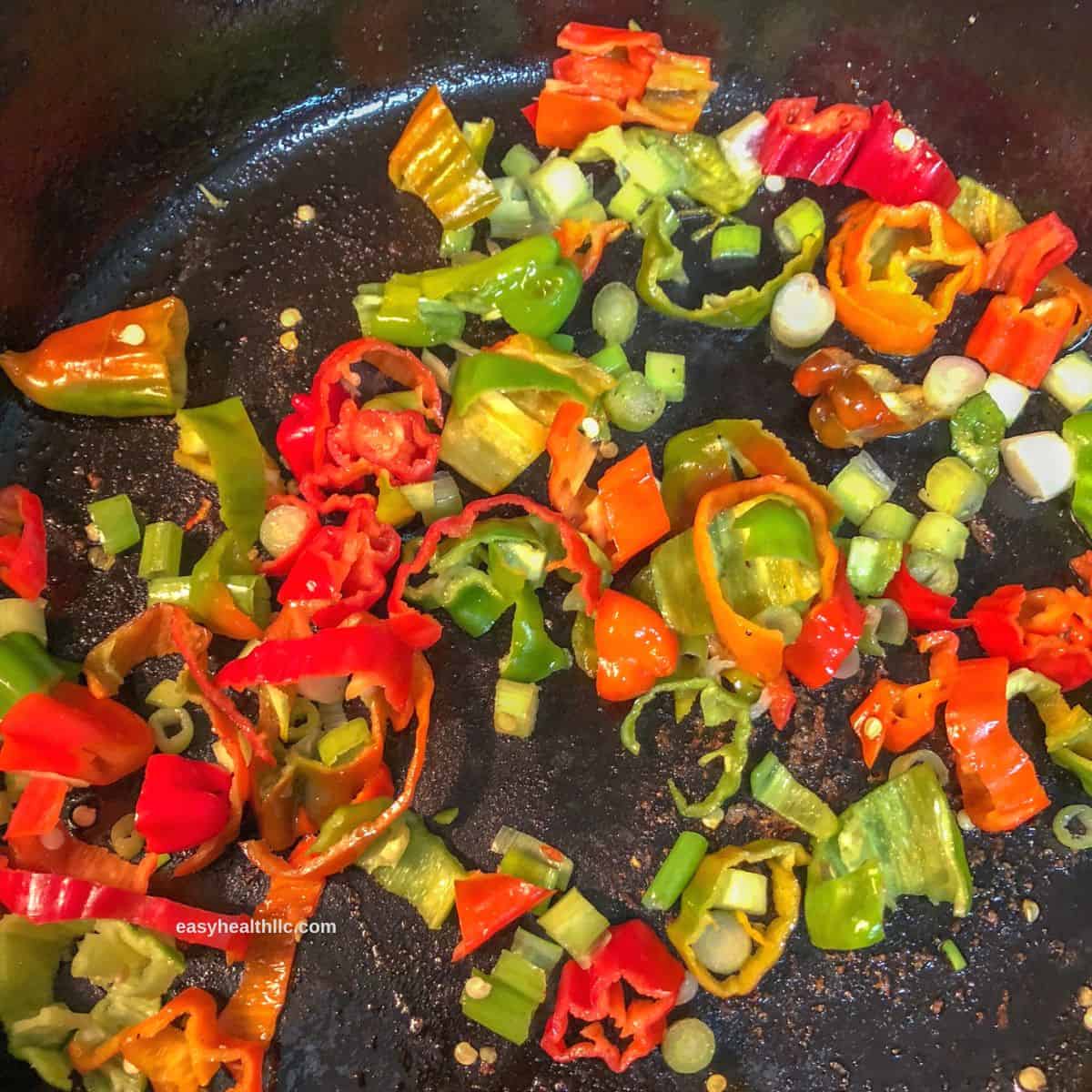 diced red and green peppers in skillet