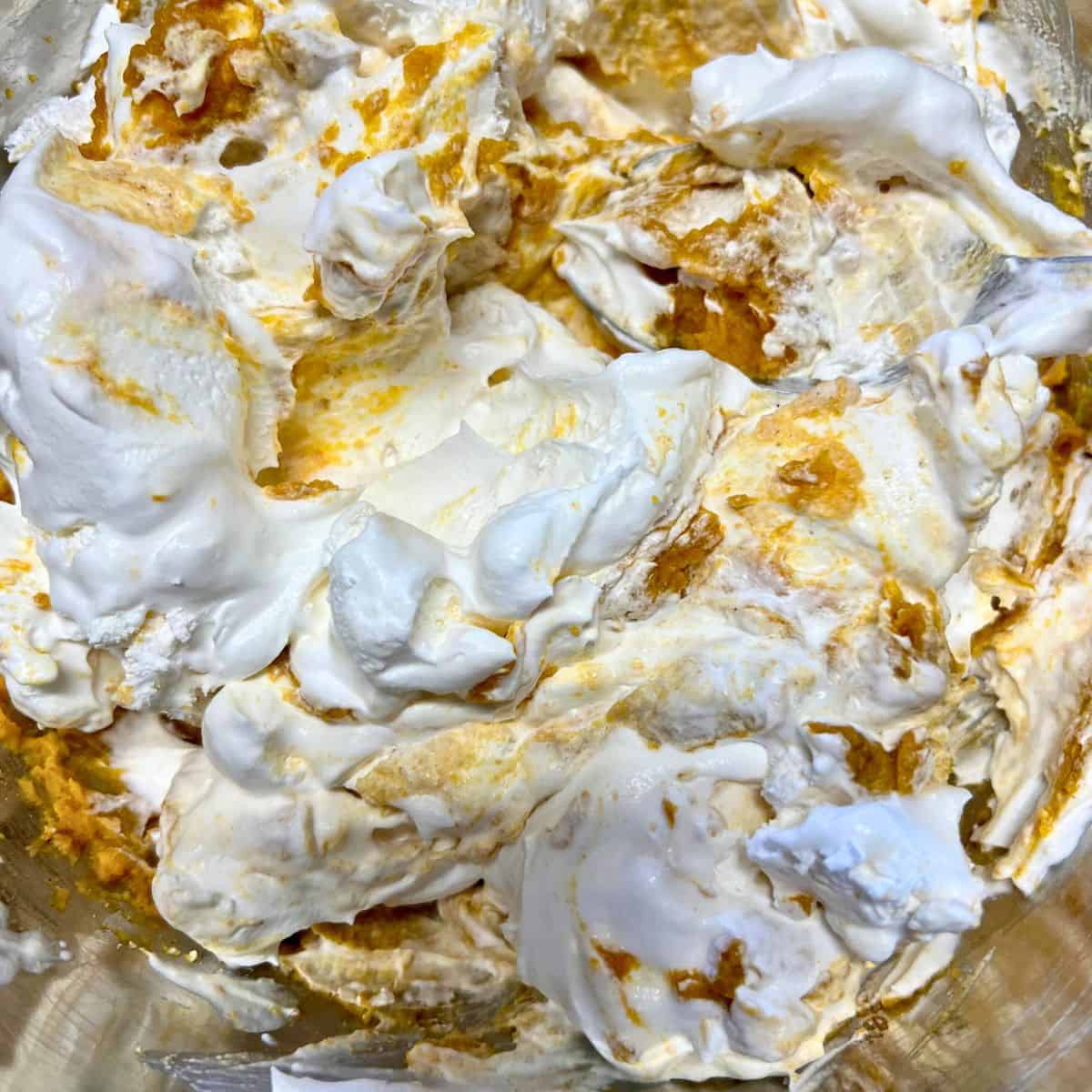 Ingredients for pumpkin fluff mixed in bowl.