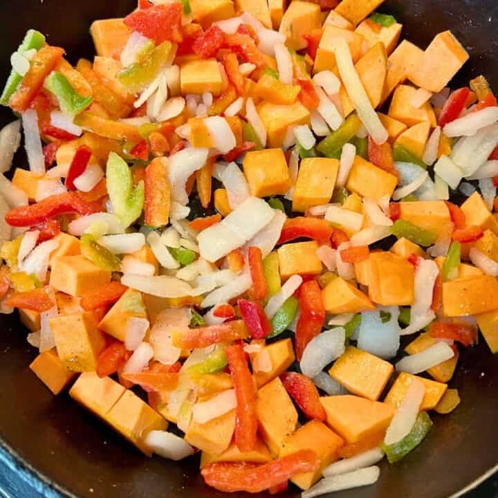 diced sweet potatoes and peppers and onions in skillet