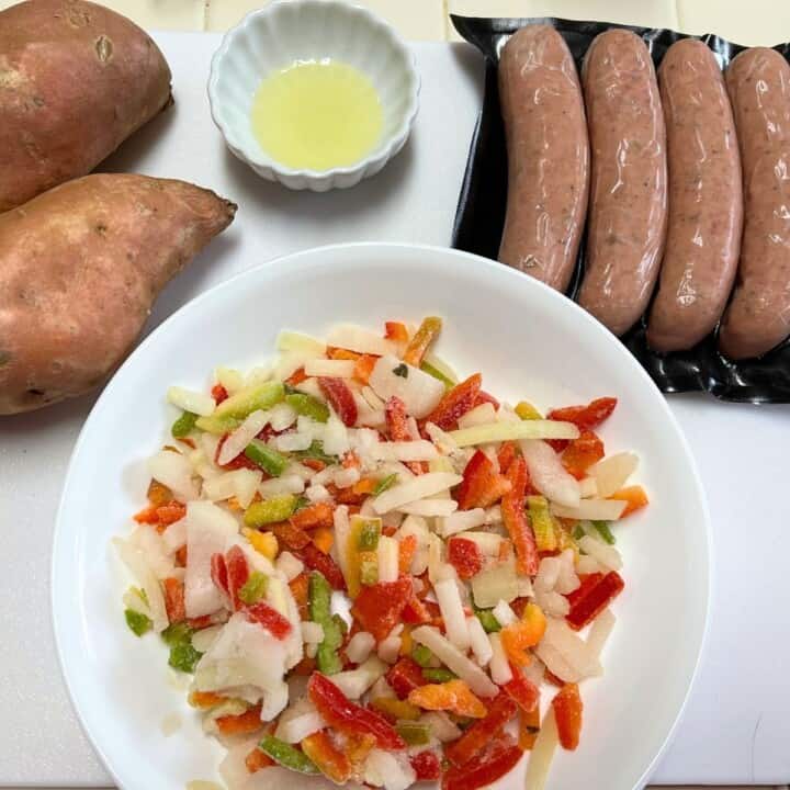 2 sweet potatoes, 4 chicken apple sausages, small bowl of olive oil and bowl of chopped peppers and onions