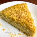 Coconut pie slice on white plate.